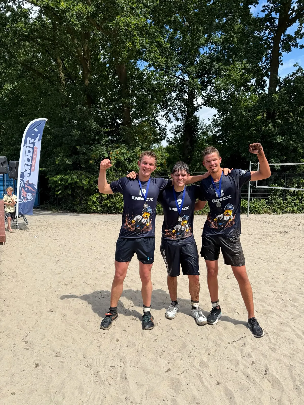 Drie teamleden in identieke bedrukte teamshirts na een toernooi