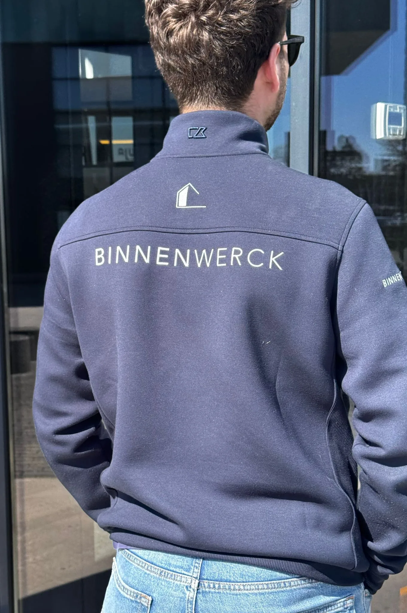 Divers team medewerkers uit horeca, kantoor en zorg in passende bedrijfskleding, glimlachend op de werkvloer